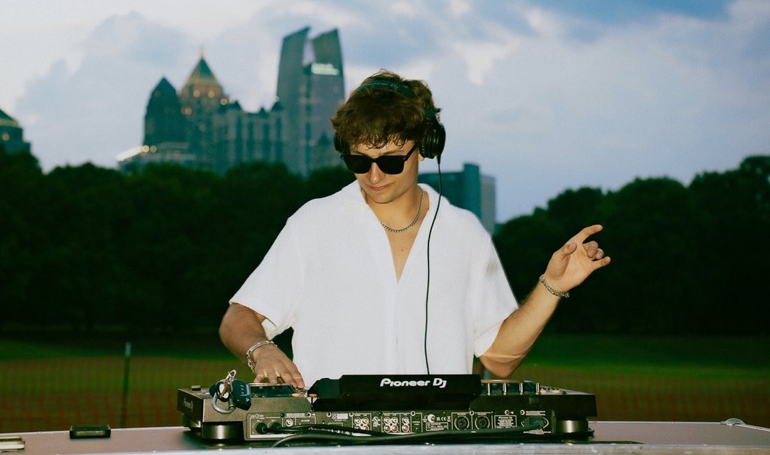 Ricky Lime DJing at sunset in Atlanta, skyline in the background